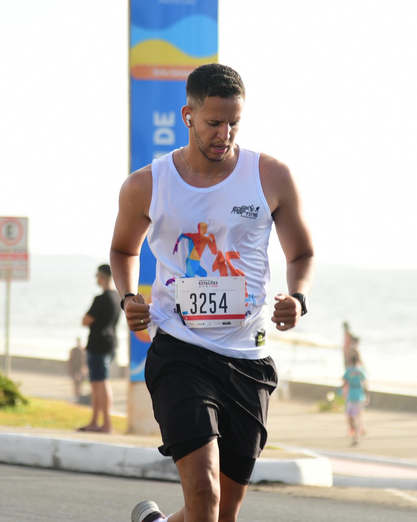 Caio correndo com regata branca na Corrida das Estações