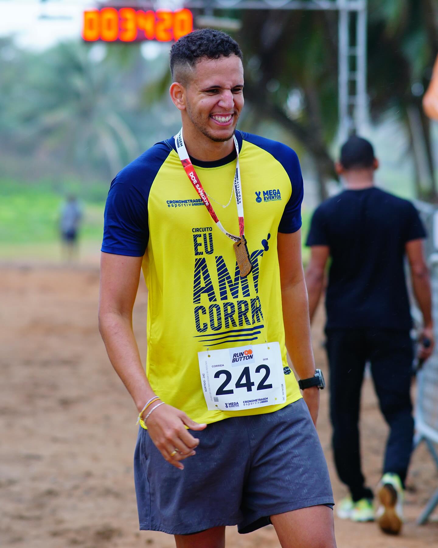 Caio sorrindo com uma medalha no peito depois de uma corrida
