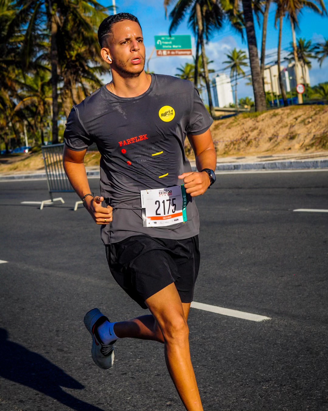 Caio em ação durante uma corrida de rua, com camiseta cinza